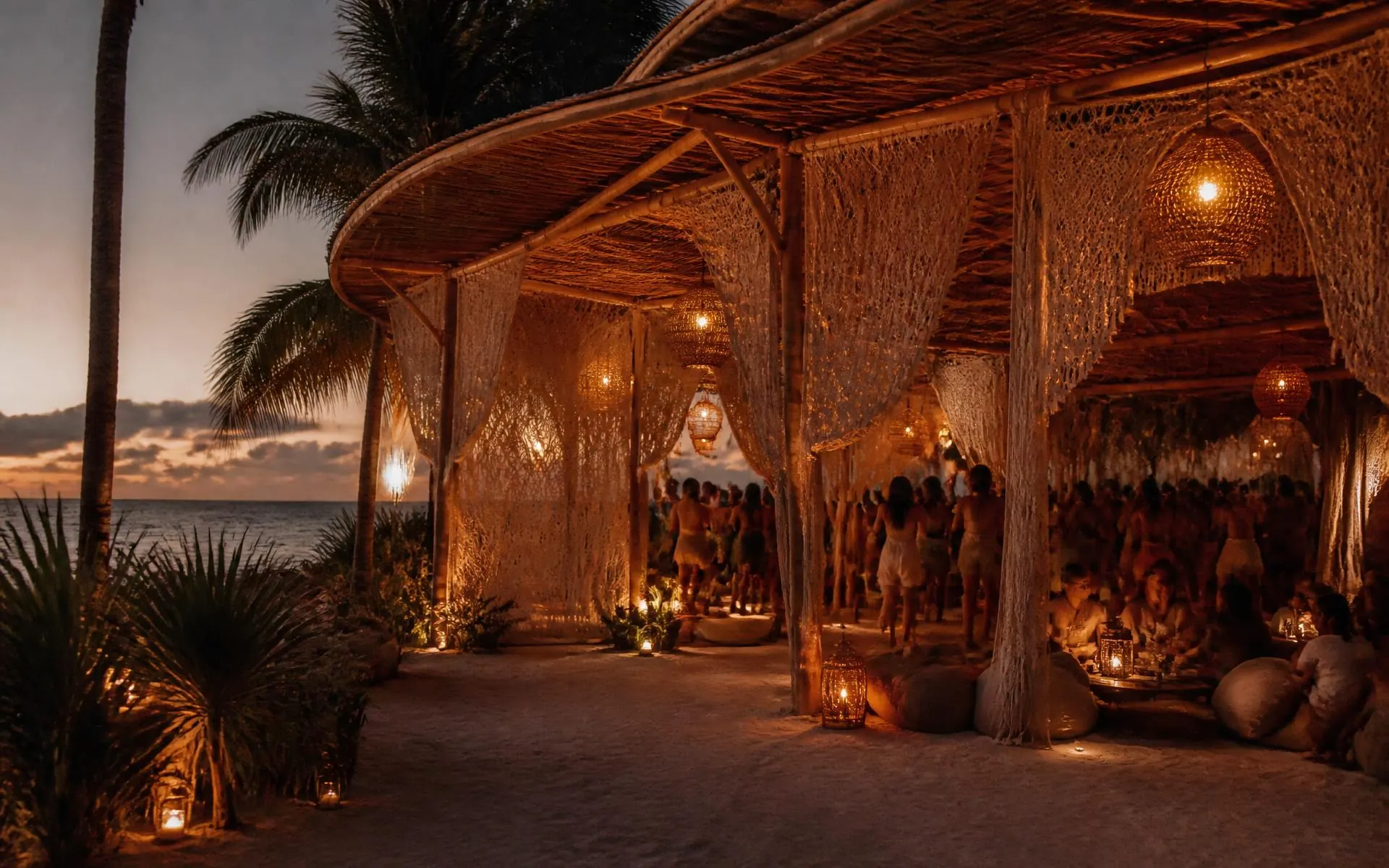 Pavilhão do Tikal Beach Club ao entardecer, com lanternas acesas e o mar ao fundo